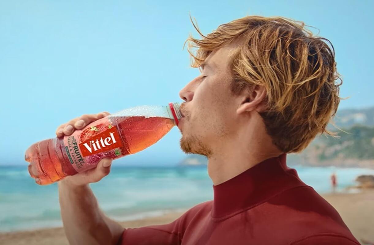 a man is drinking Vittel® Fruité